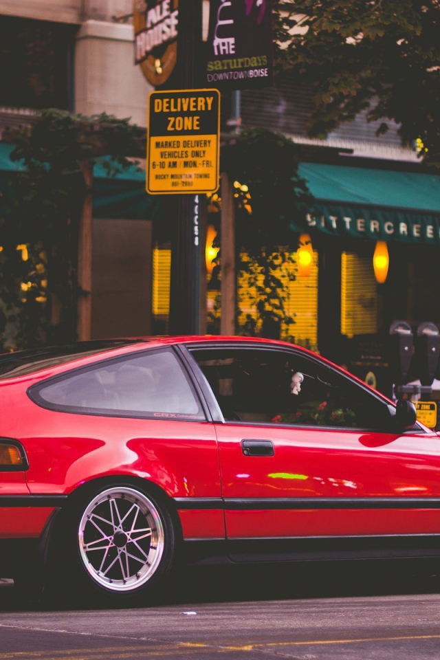 Красная Honda CRX стоит у уличного кафе