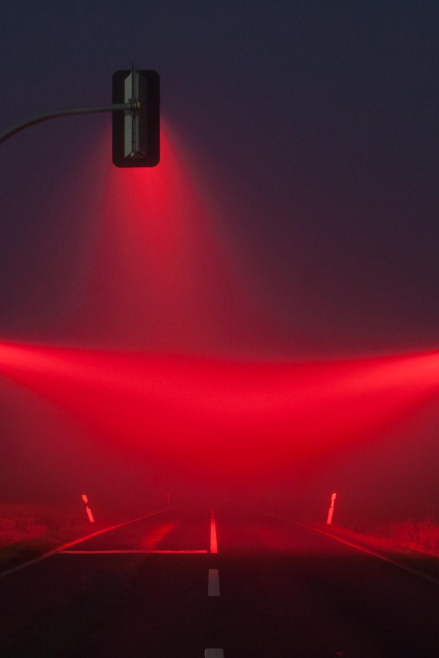 Красные светофоры освещают туман