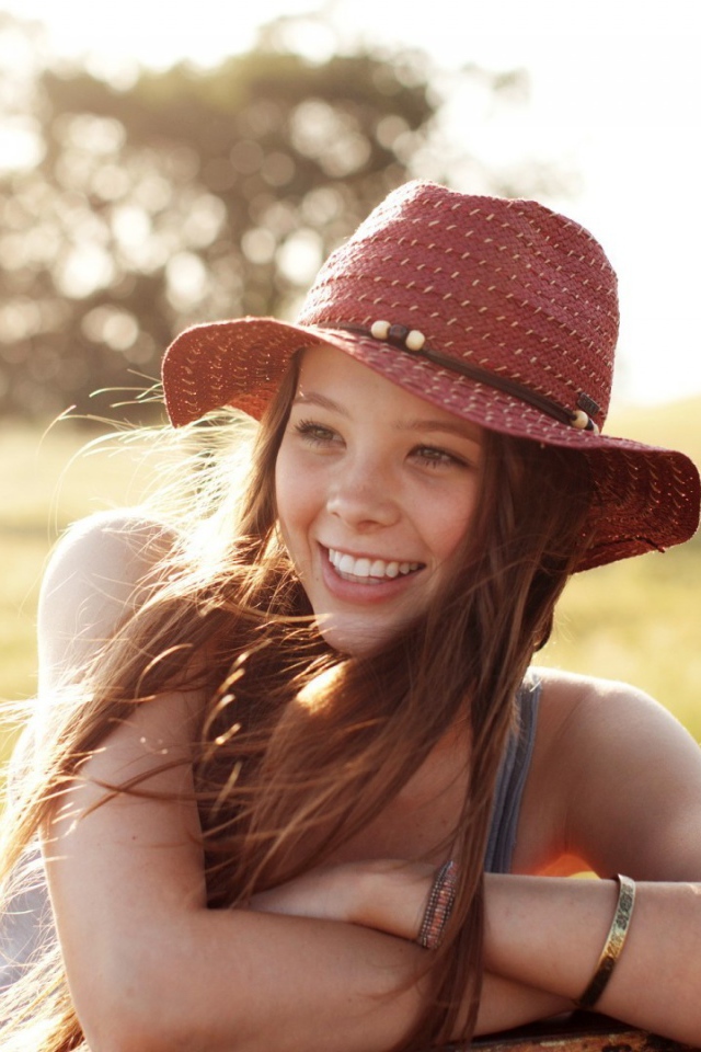 Веселая девушка в легкой красной шляпе