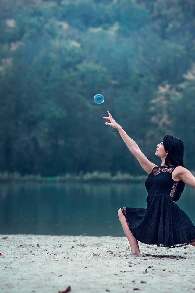 Девушка в черном платье и мыльный пузырь