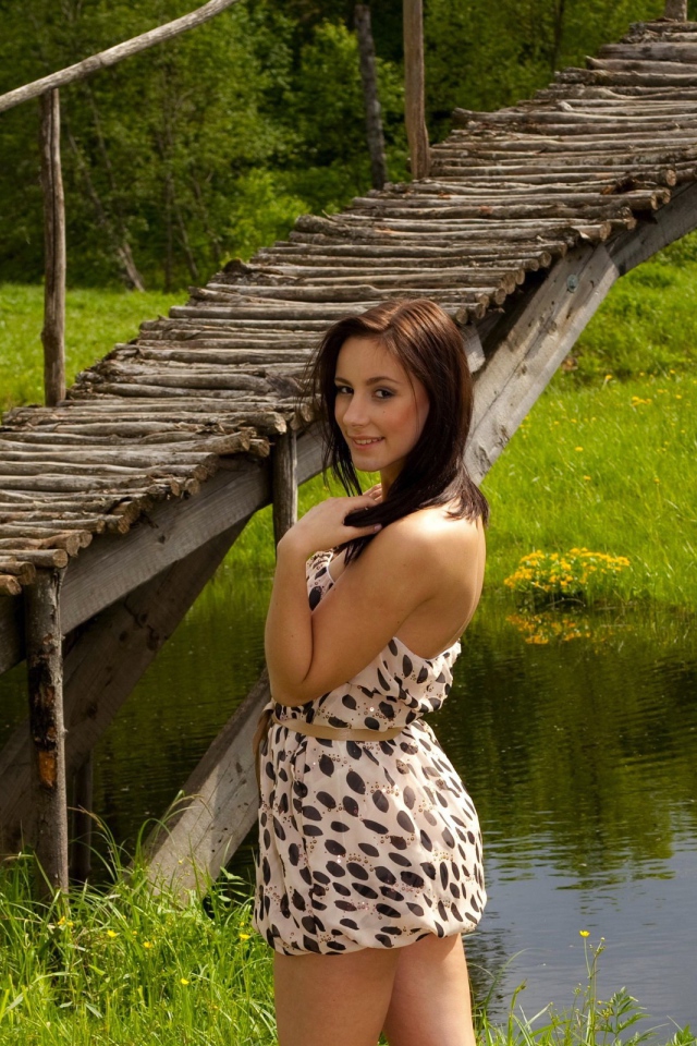 Девушка у деревянного моста через реку