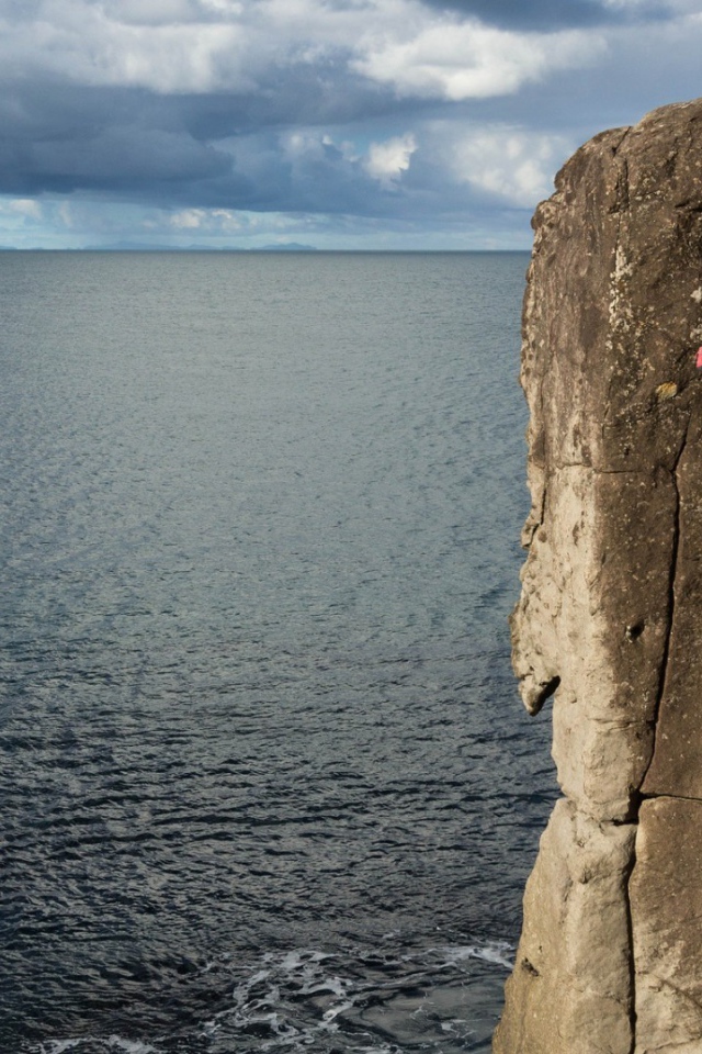 Мужчина скалолаз на скале над морем