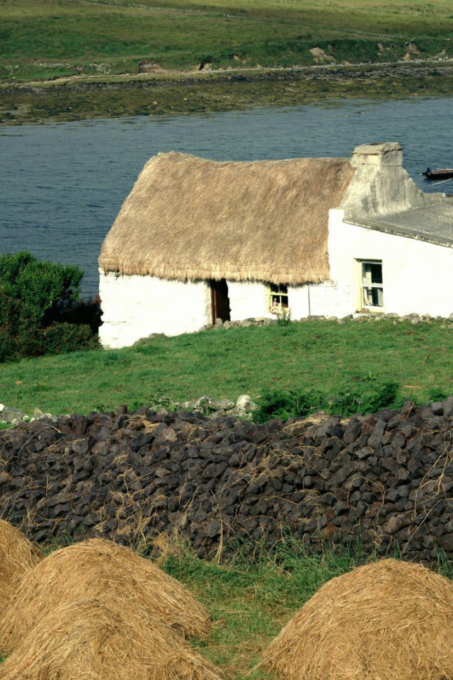 Покрытый соломой дом на берегу реки