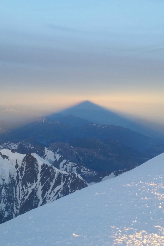Лыжники на вершине горы перед закатом солнца