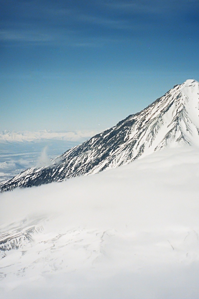 Вершина покрытой снегом горы в облаке