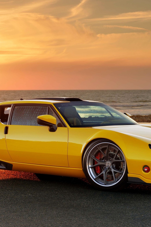 Желтый спортивный автомобиль De Tomaso Pantera на фоне заката