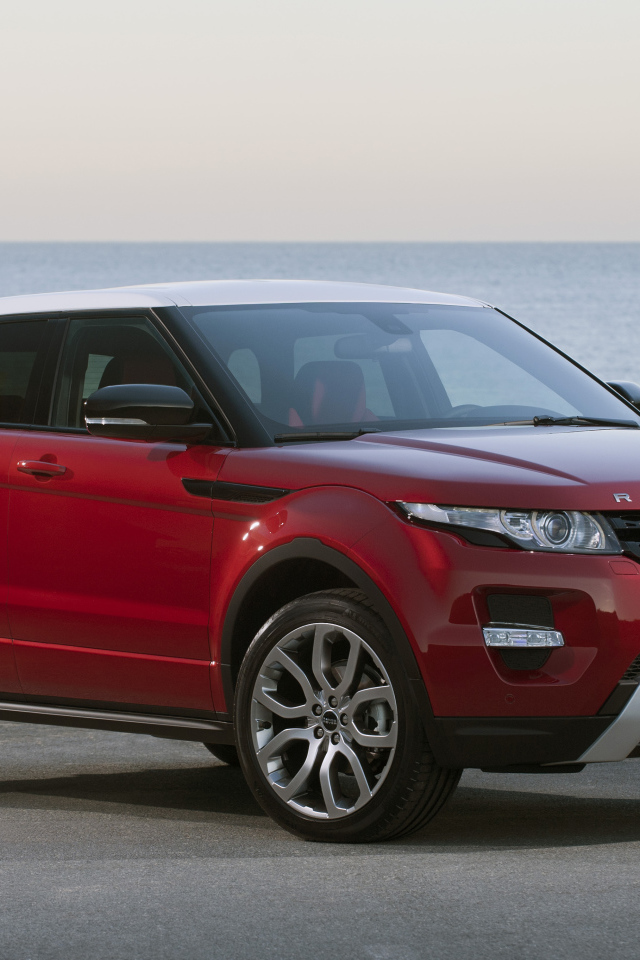 Красный автомобиль Land Rover Caractere на фоне океана