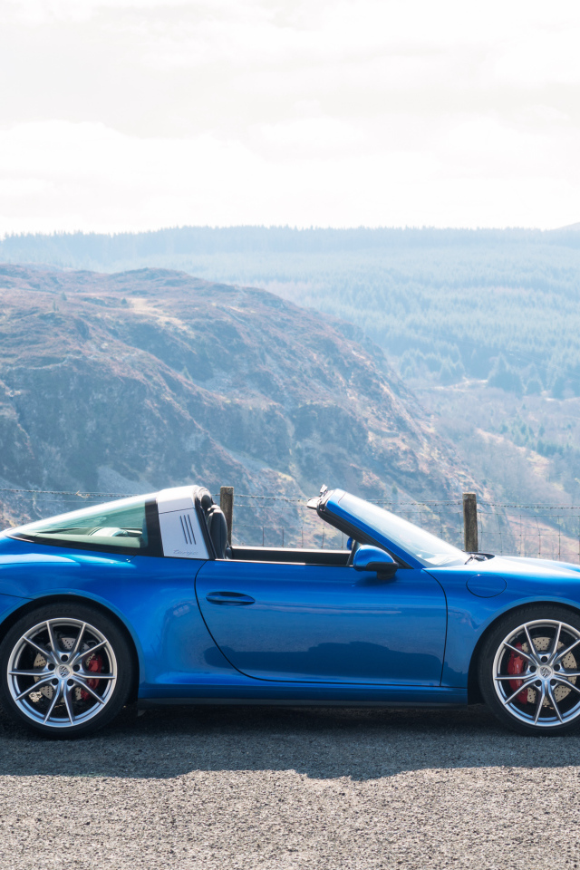 Голубой автомобиль кабриолет Porsche 911 Targa 4S на фоне гор