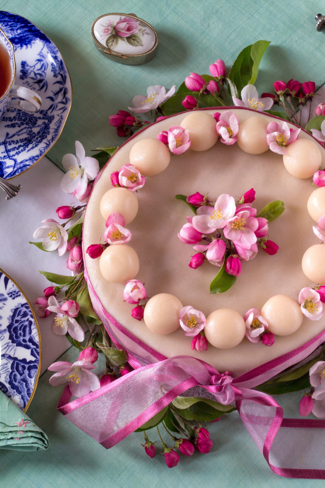 Торт с розовыми цветами на столе с красивым сервизом 