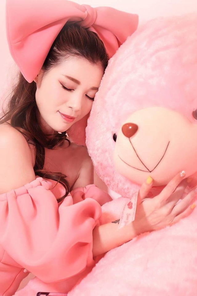 Beautiful Asian girl with a big pink bear