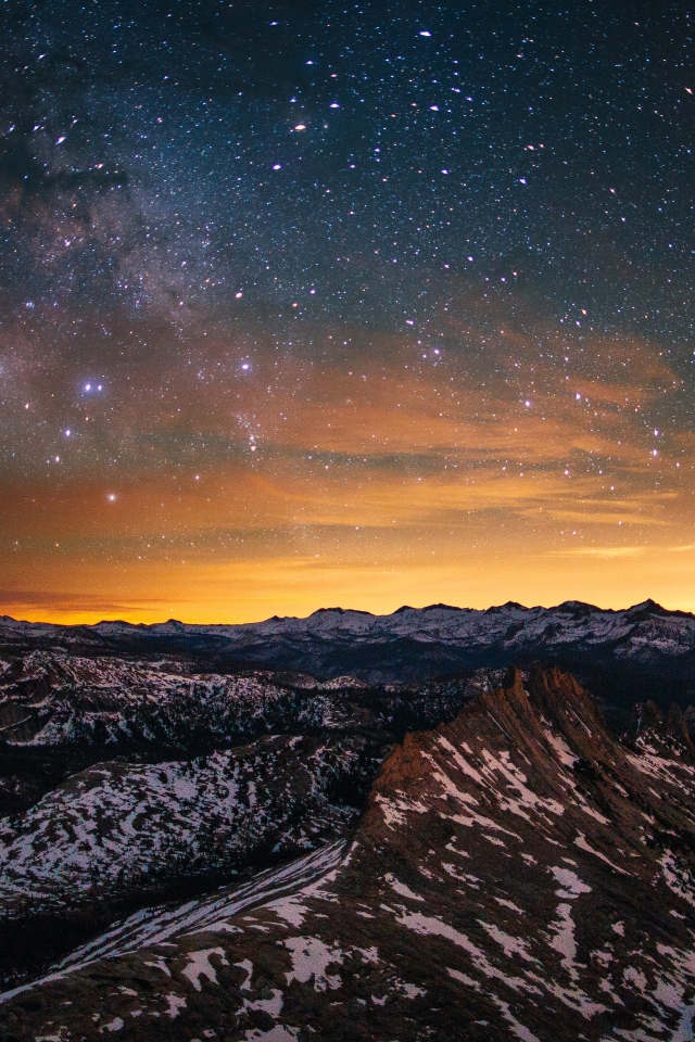Звезды и млечный путь в небе над вершинами гор