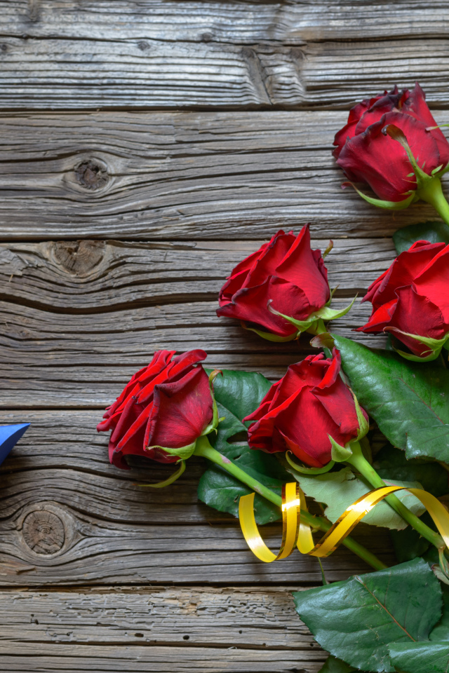 Букет красных роз на столе с синей коробочкой
