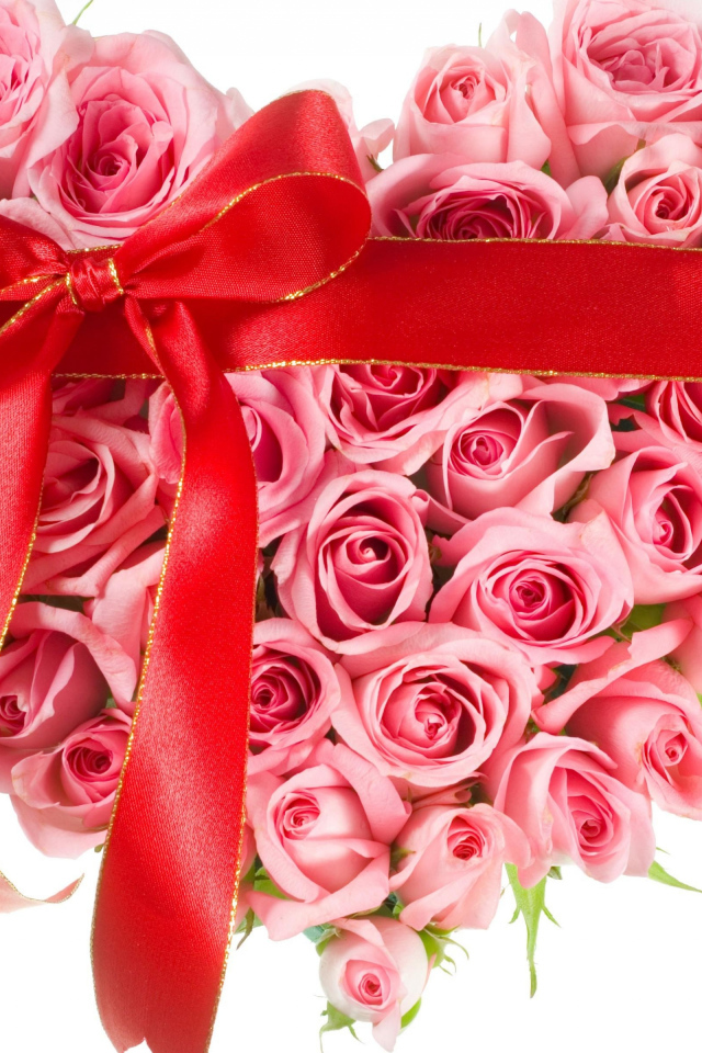Сердце из розовых роз с красной лентой на белом фоне