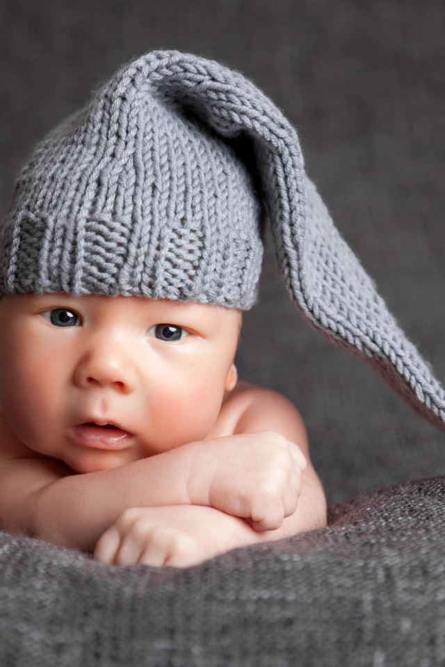 Милый младенец в большой серой вязаной шапке