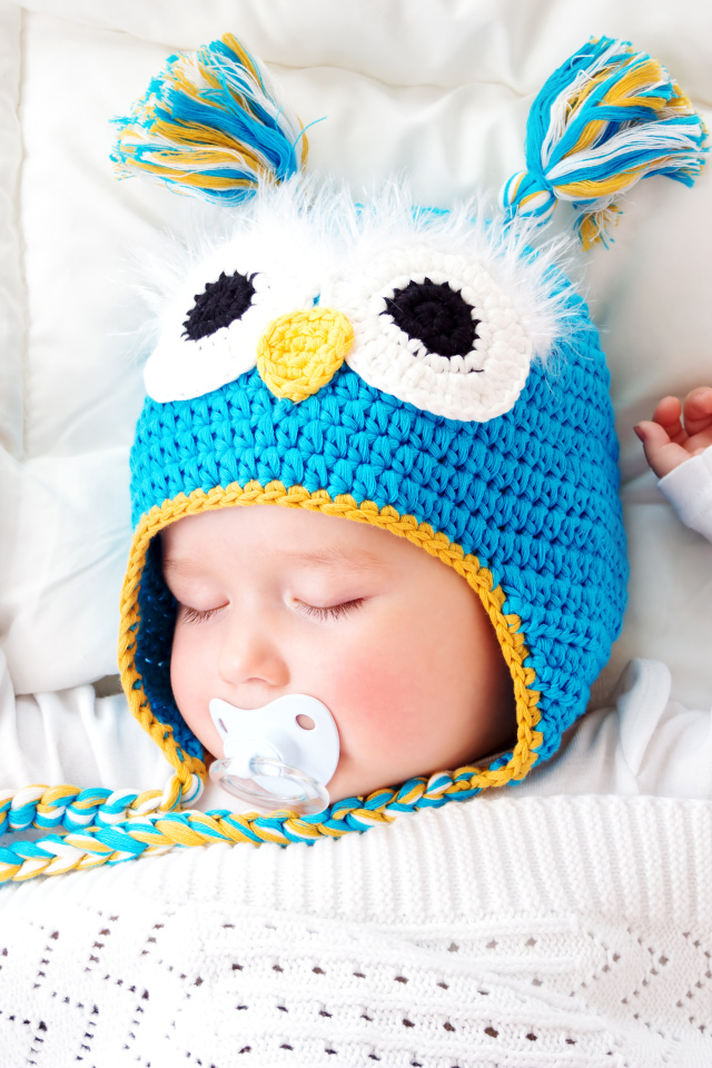 Спящий ребенок в забавной вязаной шапке