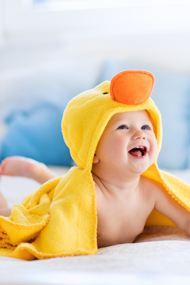 Маленький улыбающийся грудной ребенок в костюме утенка
