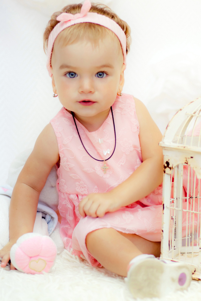 Красивая маленькая девочка в розовом платье с клеткой