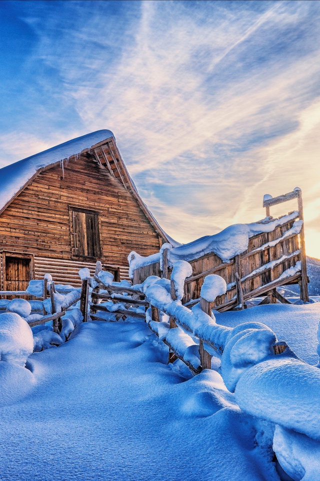 Покрытый снегом дом в горах под красивым небом