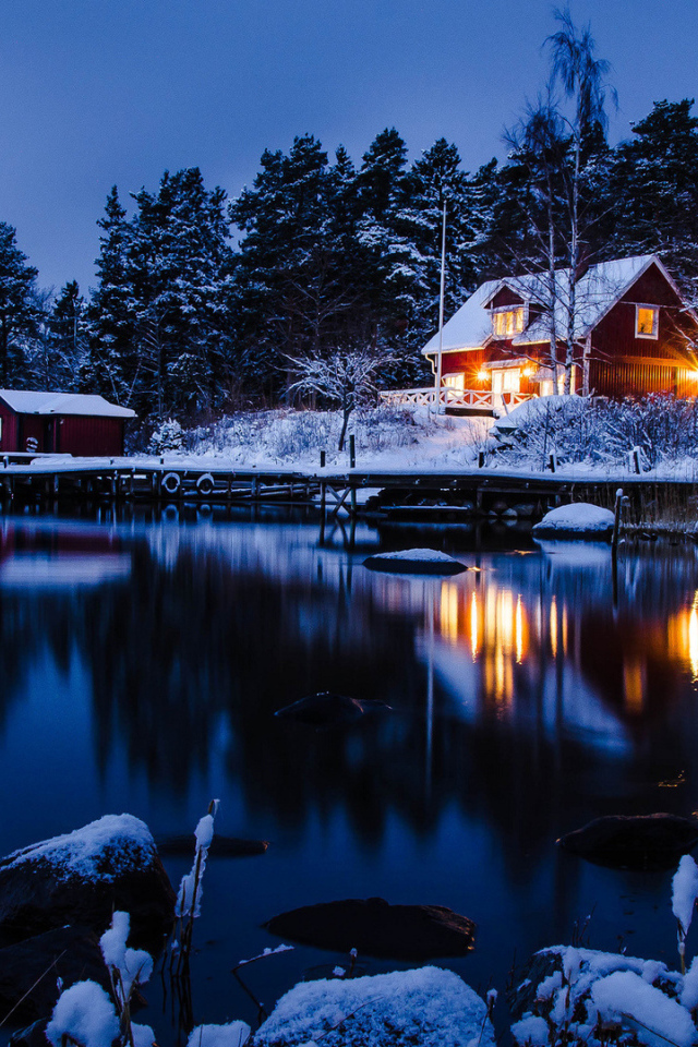 Дом у зимнего заледеневшего озера 