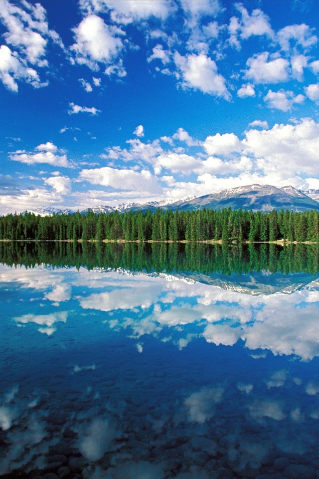 Облака отражаются в озере в национальном парке Джаспер, Канада 