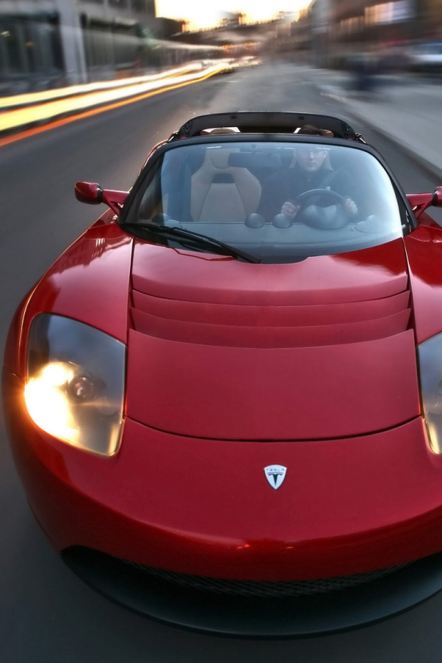 Красный электромобиль Tesla Roadster на трассе 