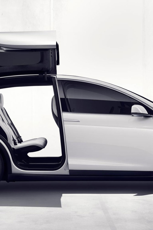 Белый электромобиль Тесла с открытыми дверями  
