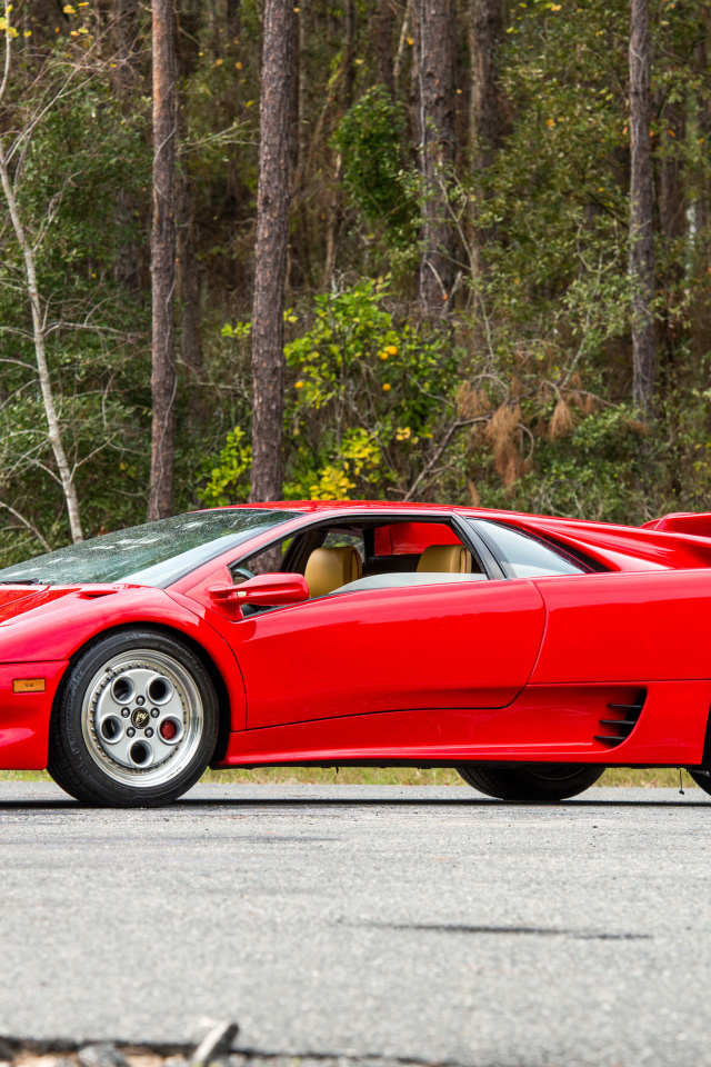 Красный спортивный автомобиль Lamborghini Diablo на фоне леса
