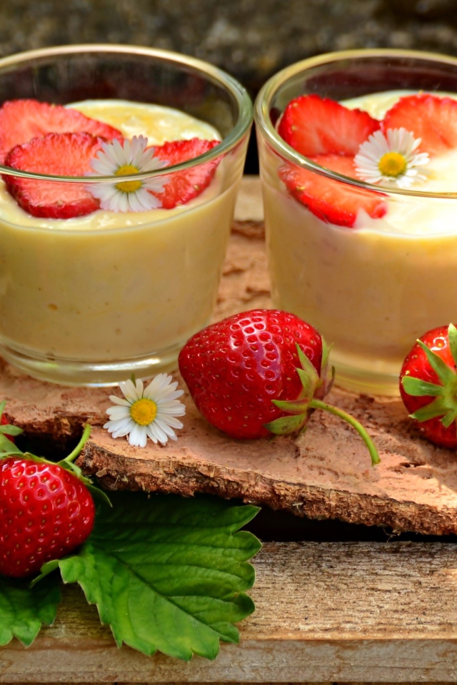 Десерт с йогуртом и свежей клубникой в стаканах на столе