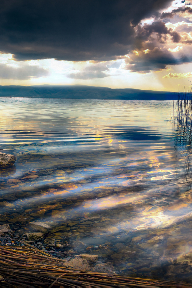 Камни в озере под красивым небом на закате