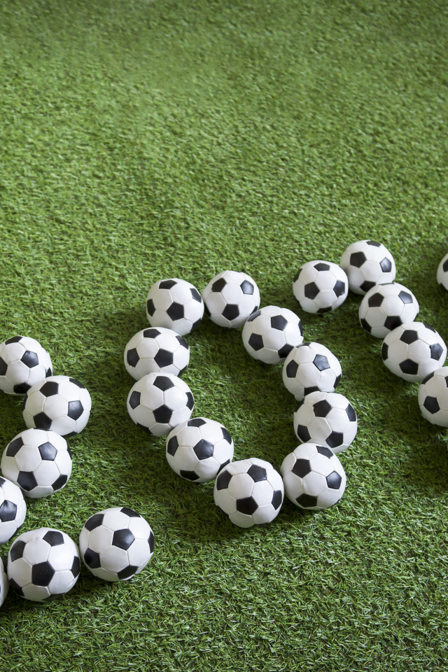 Цифры 2018 из футбольных мячей на зеленой траве