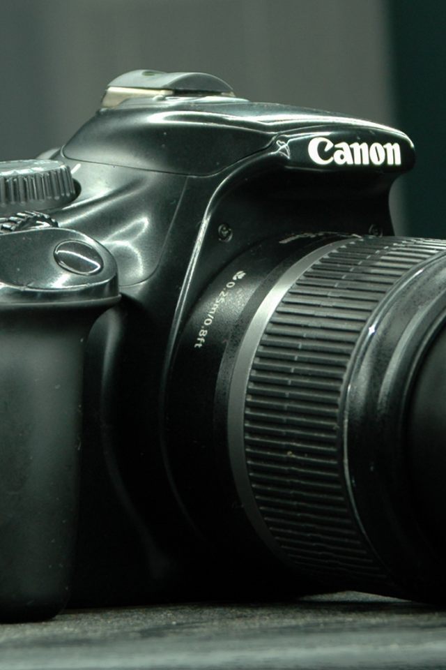 Фотоаппарат Canon 1100D лежит на столе