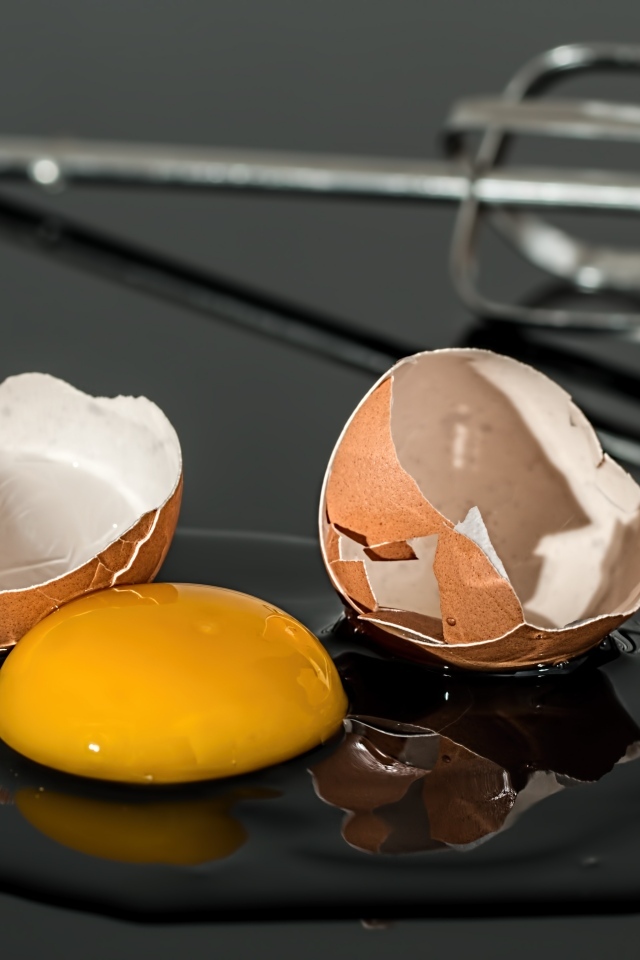 Разбитое яйцо на черном столе