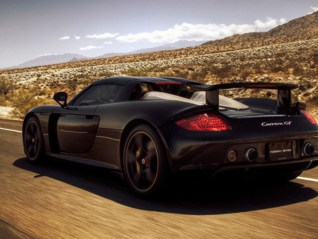 Черный автомобиль мчится по дороге