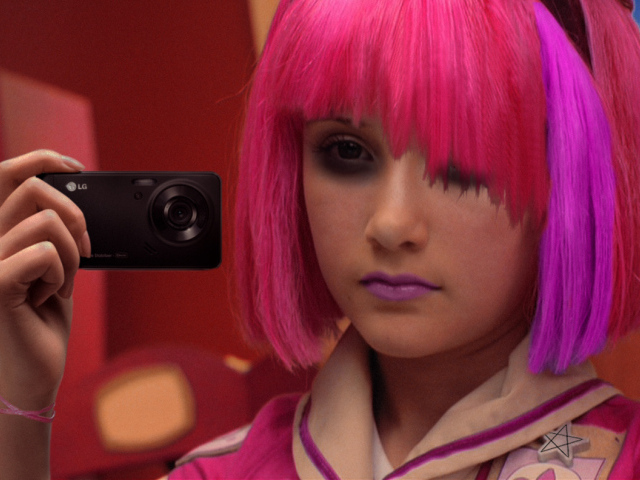 Девушка с разноцветными волосами фотографирует