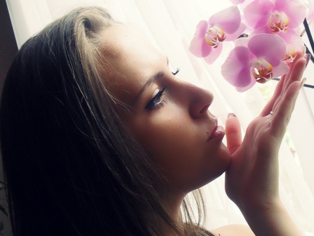 Девушка смотрит орхидею