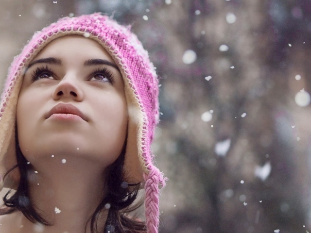 Девушка смотрит на падающий снег