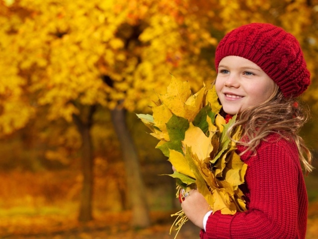 Симпатичная девочка держит осенние листья