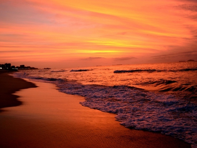 На закате волны лижут пляж