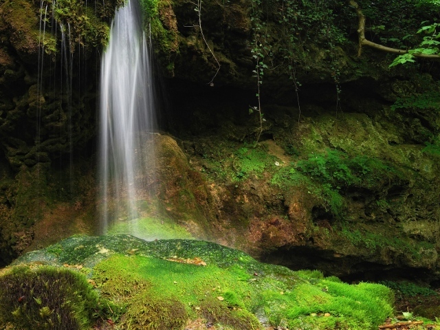 Струи воды на зеленые камни