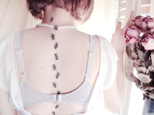 Девушка с татуировкой муравьи на спине