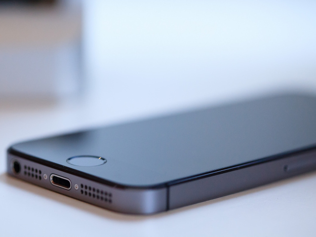 Новый Iphone 5S цвет космический серый лежит на белом столе