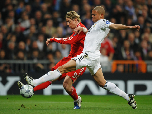 Игрок из Реал Мадрид Пепе пытается взять мяч