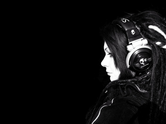 Девушка в наушниках на черном фоне