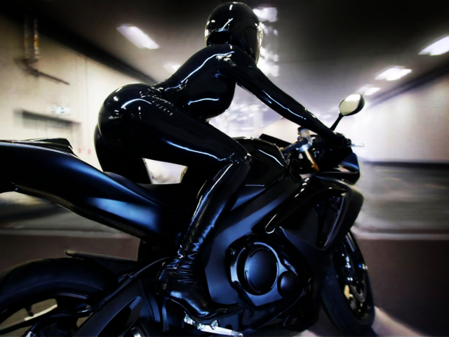 Девушка на мотоцикле в блестящем костюме