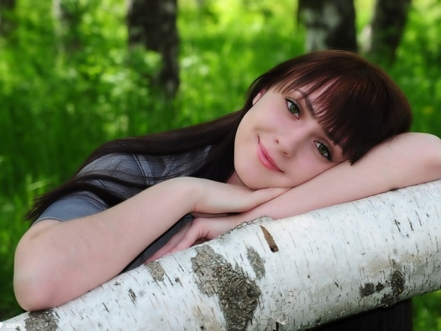 Девушка улыбается в лесу