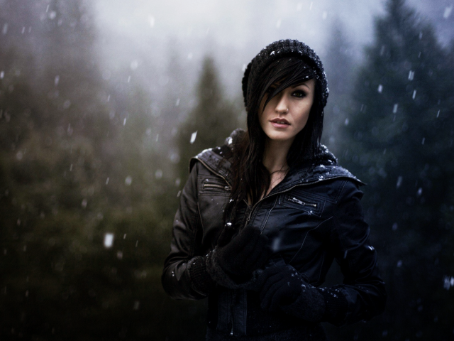 Брюнетка в куртке под снегом