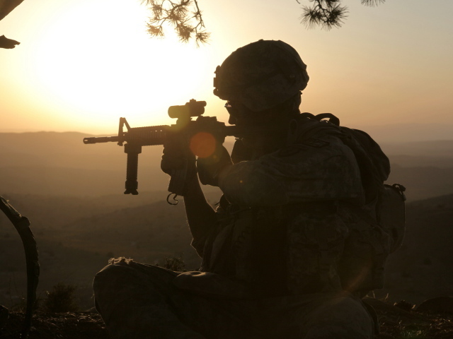 Солдат с оружием на закате