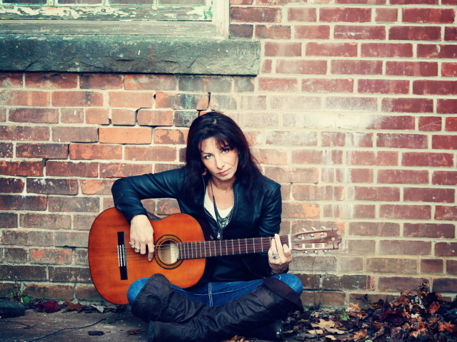 Девушка с гитарой у стены