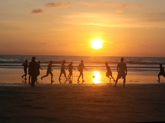 Парни играют в футбол на пляже в Гоа
