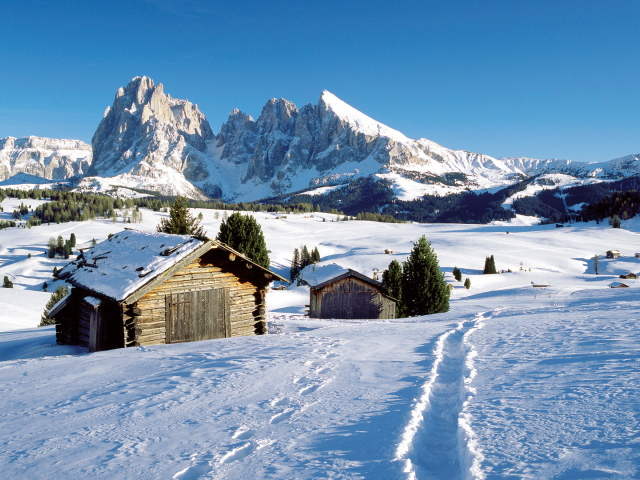 Дома на фоне гор на горнолыжном курорте Валь Гардена, Италия